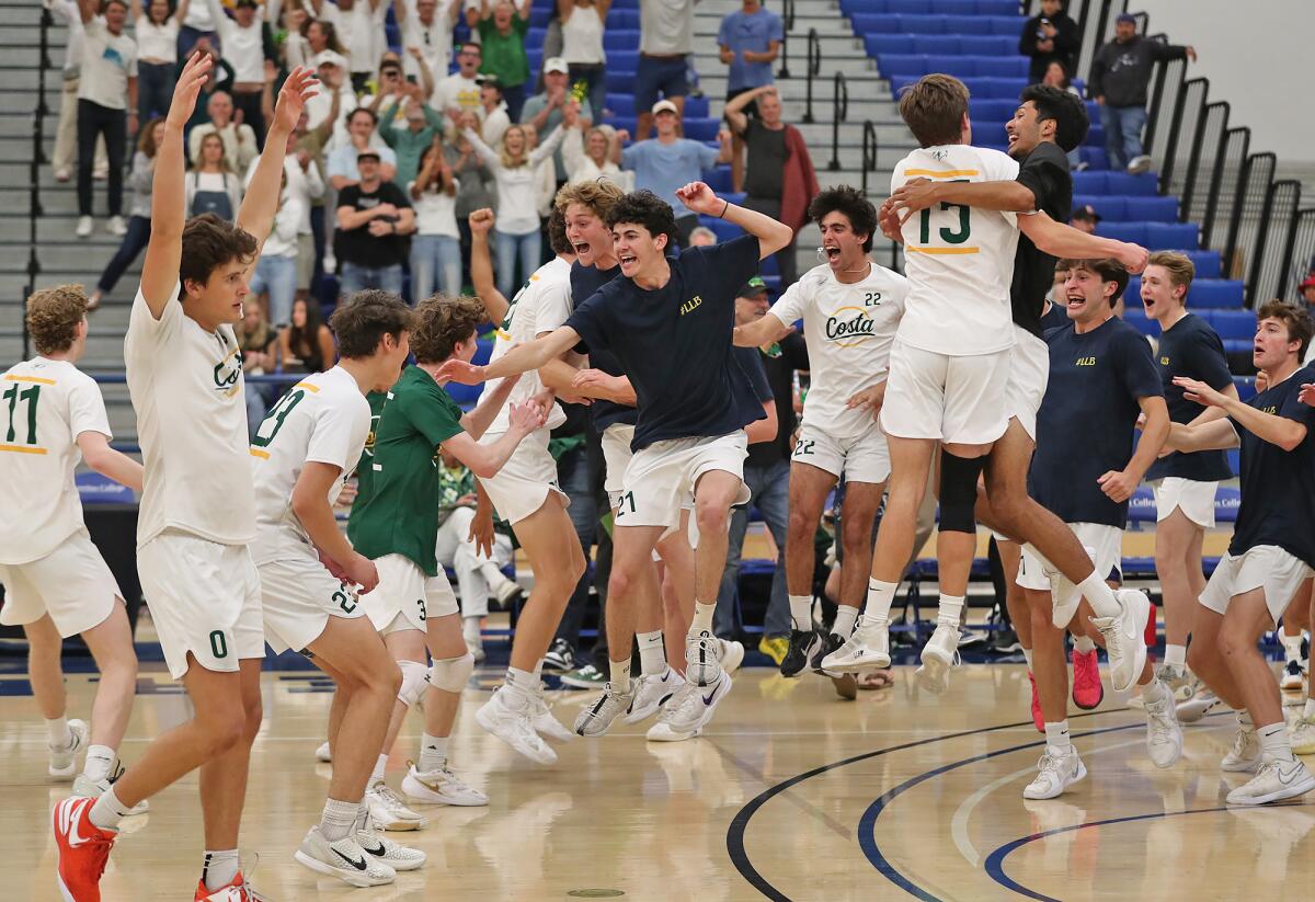 Mira Costa rushes the court after defeating Huntington Beach in the CIF Southern Section Division 1 boys' volleyball final.