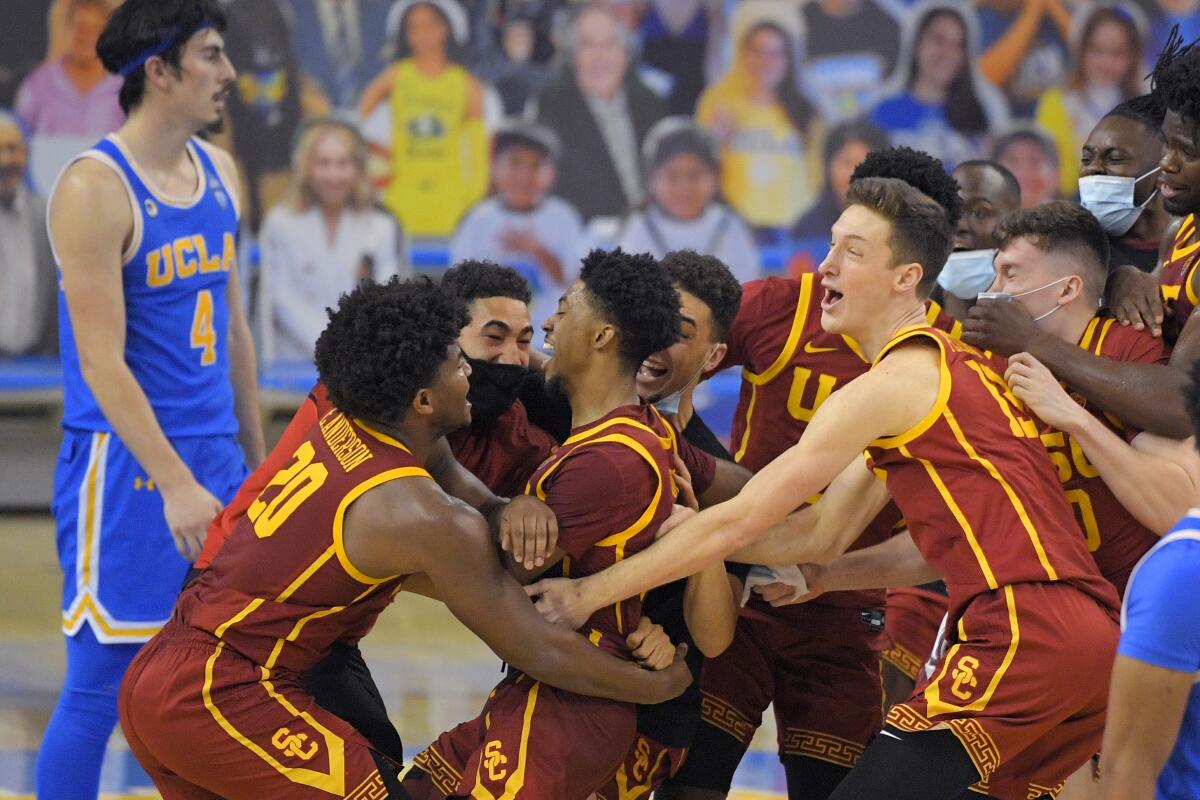 USC players celebrate following the Trojans' win over UCLA on March 6, 2021, at Pauley Pavilion.