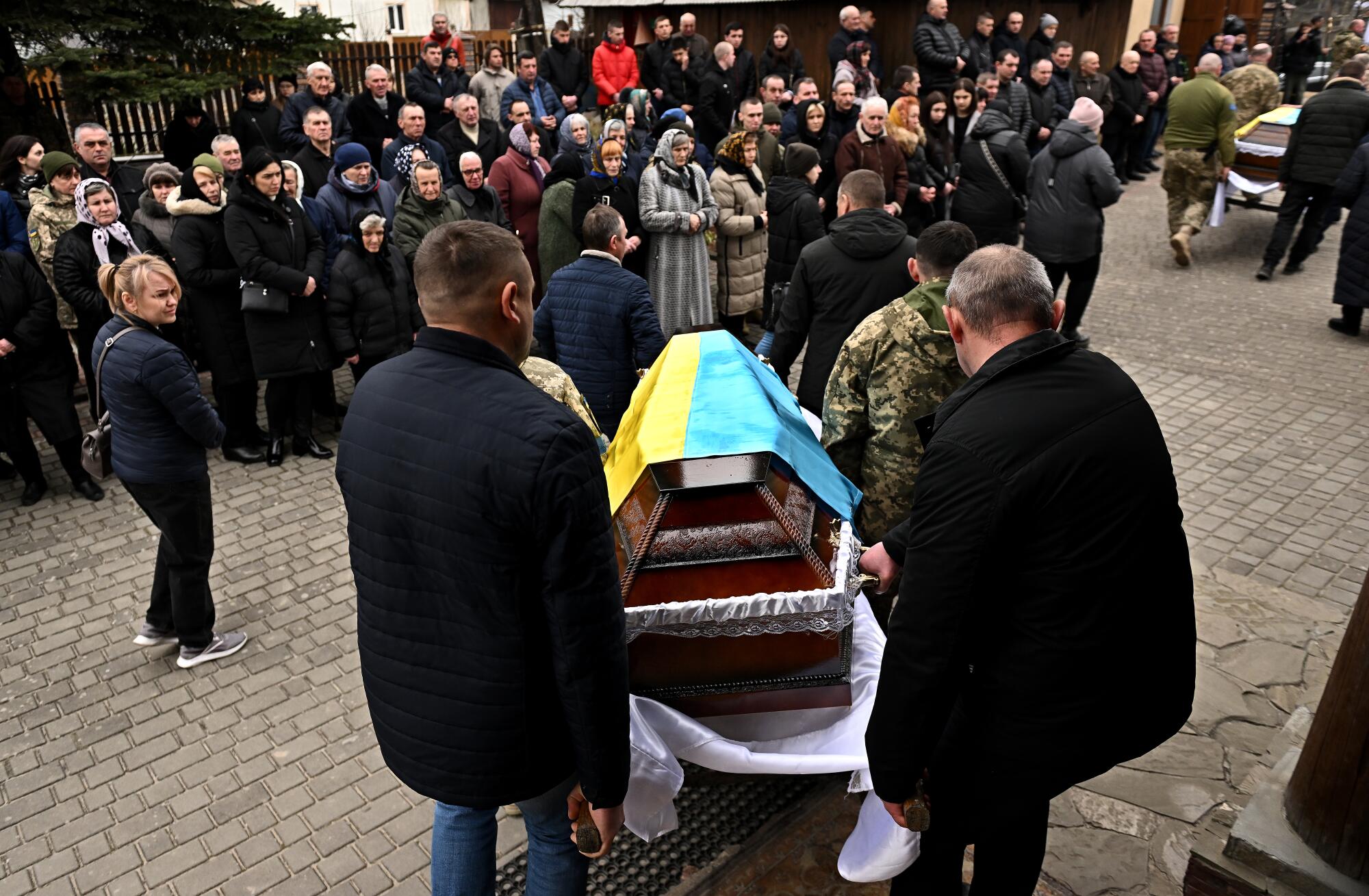  People carry a casket outdoors.