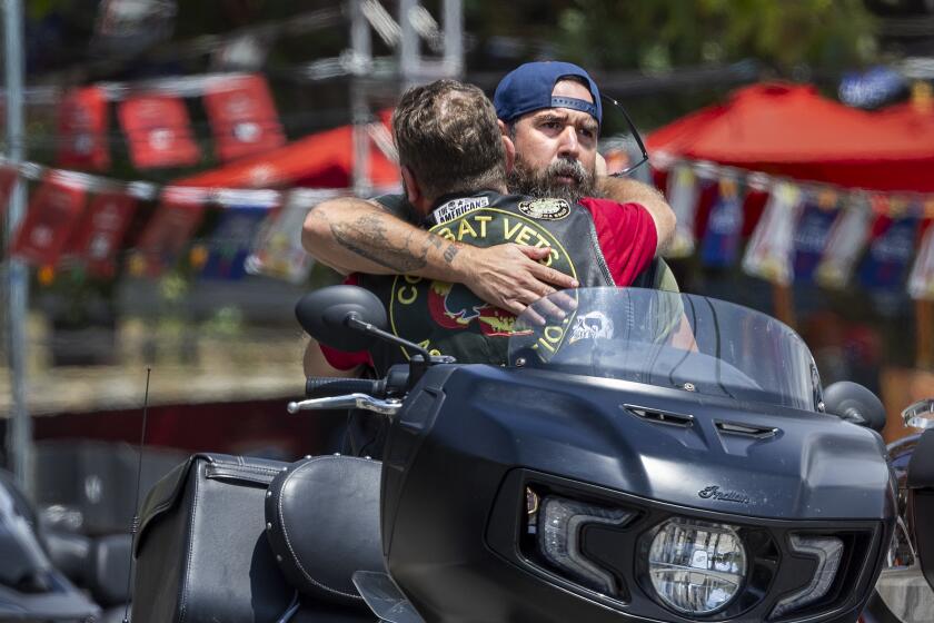 Trabuco Canyon, CA - September 01: Members of the Combat Veterans Association motorcycle club hug after arriving on their motorcycles to return to the scene and offer comfort to fellow bikers and friends after last week's mass shooting at Cook's Corner in Trabuco Canyon Friday, Sept. 1, 2023. "A I got off my bike, I felt the presence of the Holy Spirit and had to raise my arms in prayer" Lopez said. "I was praying to lift their spirit and give them peace in Heaven and to bring this building peace, love and happiness", Lopez said. Cook's Corner, the Trabuco Canyon bar where a gunman killed three people and injured six others before being fatally shot by Orange County sheriff's deputies, reopens, with the manager saying she wants to ``bring the family back together.'' In a video posted Thursday on Facebook, Cook's Corner general manager Rhonda Palmeri said she's been asked by many people when the venue will reopen following the Aug. 23 shooting.(Allen J. Schaben / Los Angeles Times)