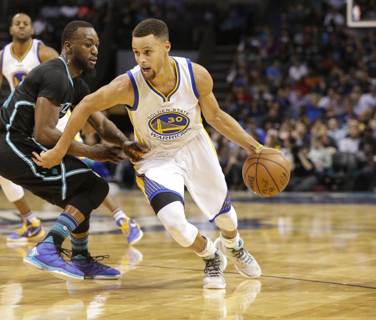 Warriors guard Stephen Curry drives past Hornets guard Kemba Walker in the second half.