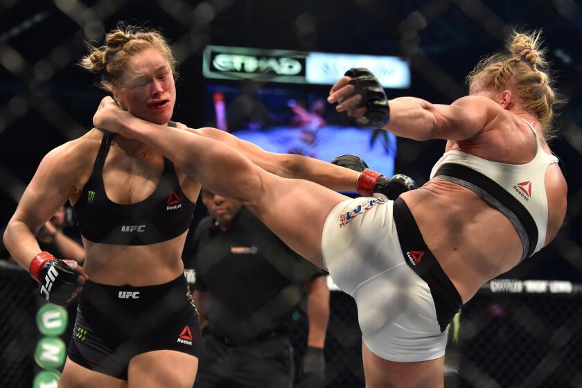 Holly Holm, right, lands a kick to the neck to knock out Ronda Rousey at UFC 193 in Melbourne, Australia, on Nov. 15, 2015.