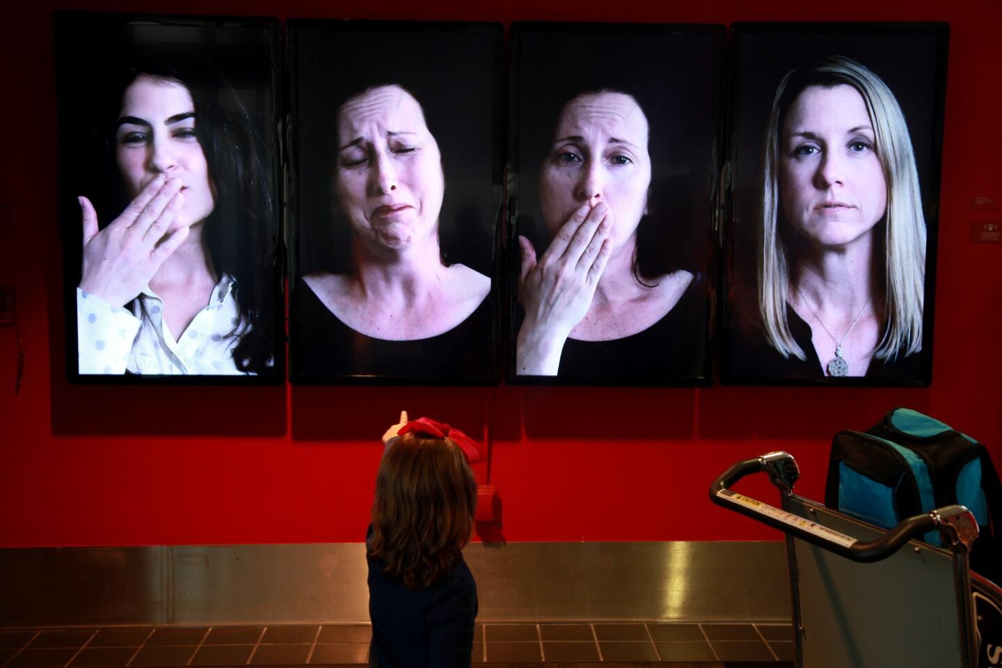 "Blow Me a Kiss" by Eileen Cowin features video monitors with various people saying goodbye.