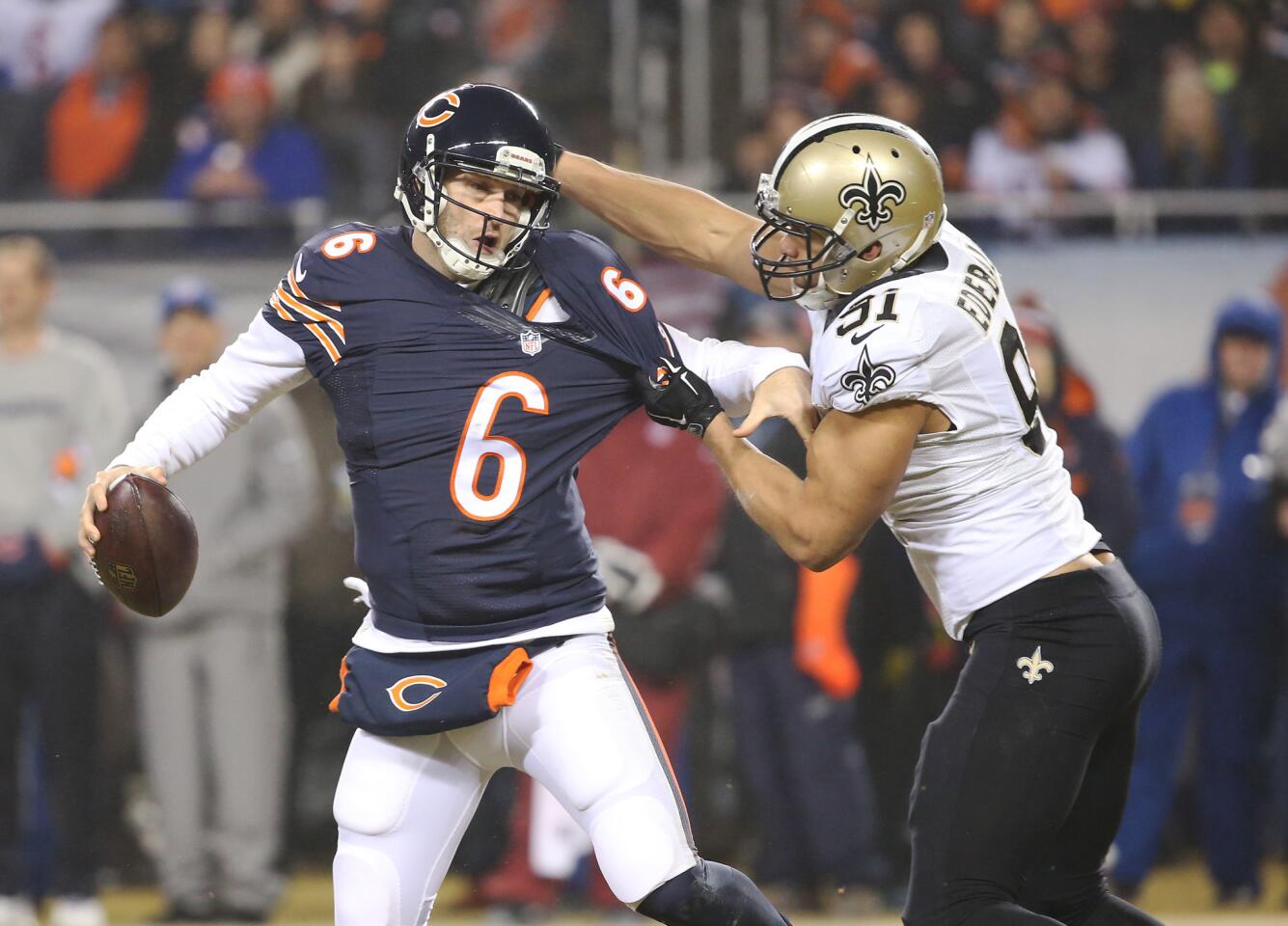 Bears quarterback Jay Cutler is dragged down by the Saints' Kasim Edebali in the second quarter.