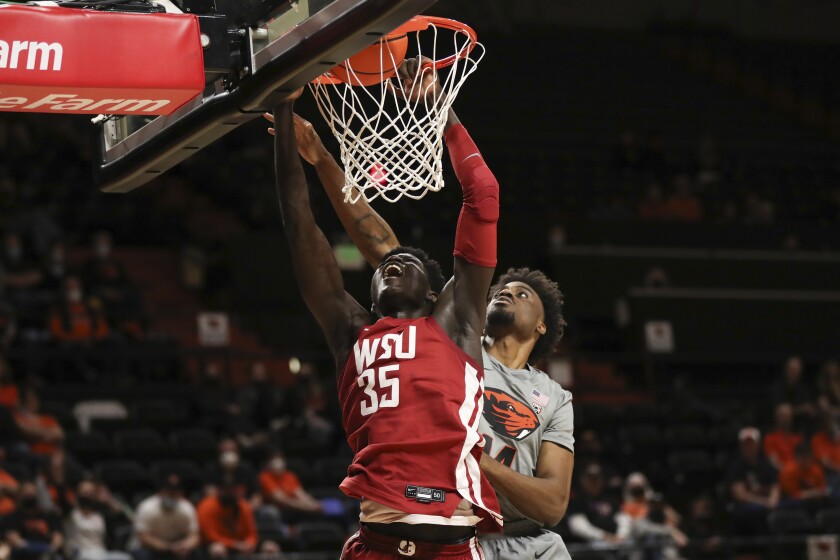 Washington State forward Mouhamed Gueye dunks in front of Oregon State forward Ahmad Rand during the second half of an NCAA college basketball game on Monday, Feb. 28, 2022, in Corvallis, Ore. Washington State won 103-97. (AP Photo/Amanda Loman)