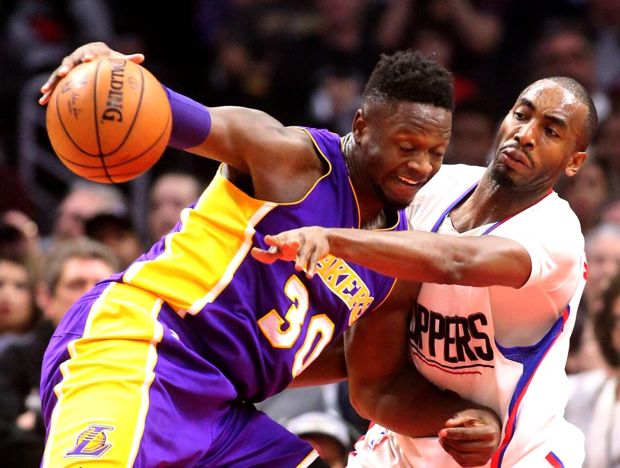 Lakers forward Julius Randle drives against Clippers forward Luc Mbah a Moute during the first half Saturday afternoon at Staples Center.