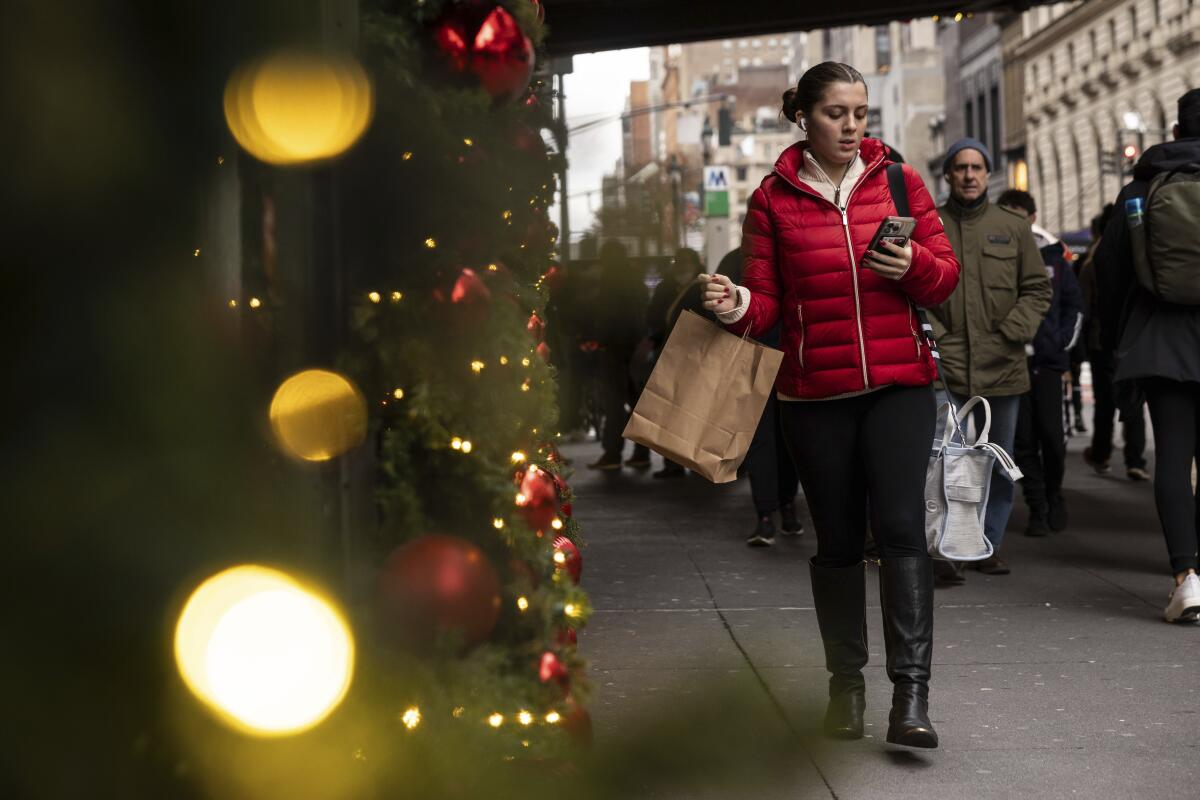 A woman carrying a shopping bag passes Macy's department store in New York