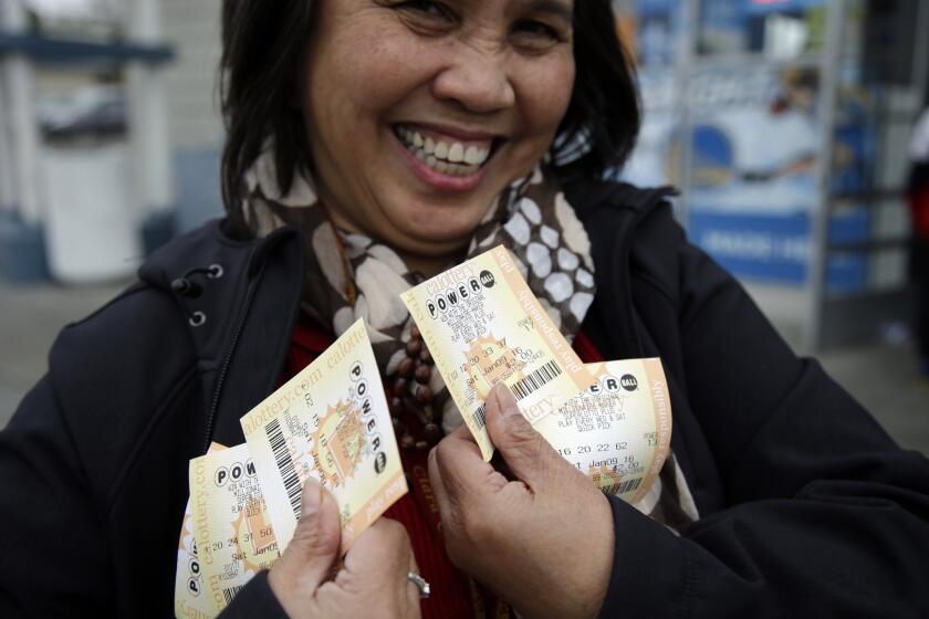 Zaida Cobangbang, of Union City, Calif., shows her Powerball tickets shortly after buying them Saturday in San Lorenzo, Calif.