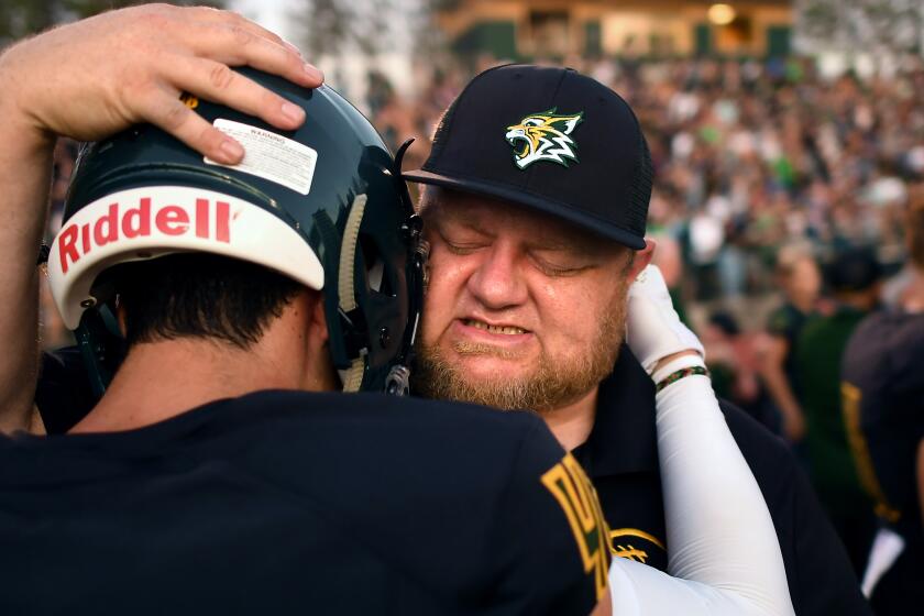 PARADISE, CALIFORNIA AUGUST 23, 2019-Assistant Paradise football coach Andy Hopper cries as he hugs running back Tyler Harrison before their first game of the season. (Wally Skalij/Los Angeles Times)