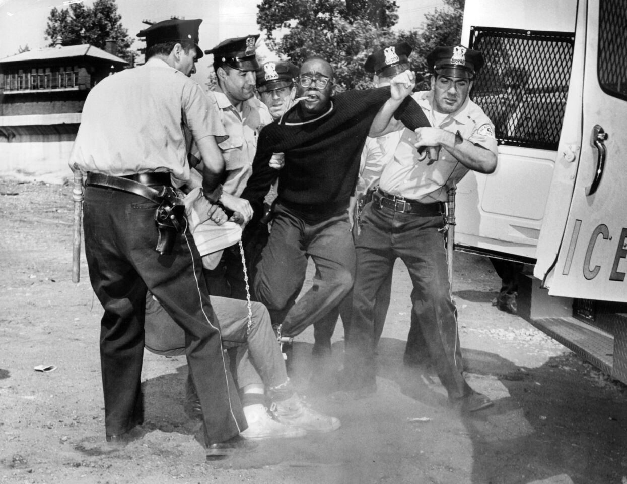 Demonstrators, chained together are carried to a patrol wagon by Chicago police officers on Aug. 13, 1963, at 73rd Street and Lowe Avenue in the Englewood neighborhood. The group was protesting school segregation.