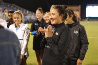 New UCLA coach Margueritte Aozasa celebrates with her team following a season-opening win over Iowa on Aug. 18 in Westwood.