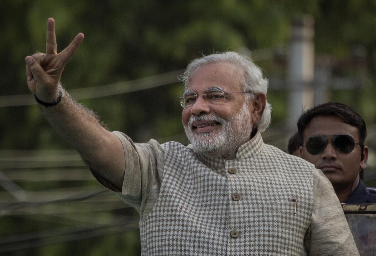 India's conservative party leader, Narendra Modi, flashes a victory sign before addressing supporters in Vadodara.