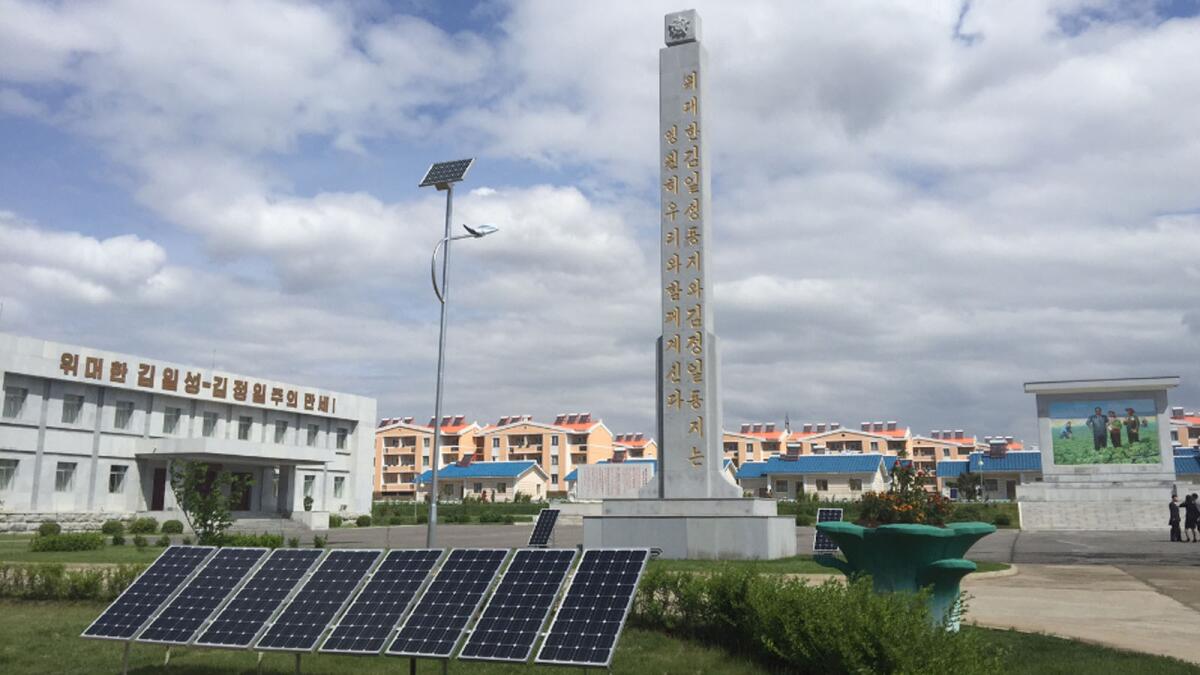 Solar panels in front of a monument at a farm on the eastern outskirts of Pyongyang.