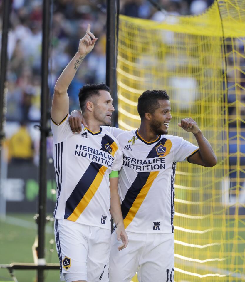 Los Angeles Galaxy's Robbie Keane, left, celebrates his goal with Giovani dos Santos during the second half of an MLS soccer match against the Orlando City FC, Sunday, Sept. 11, 2016, in Carson, Calif. The Galaxy won 4-2. (AP Photo/Jae C. Hong)