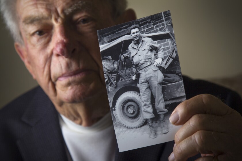 Oceanside resident Jack Port, 96, with a photo of himself at age 22.