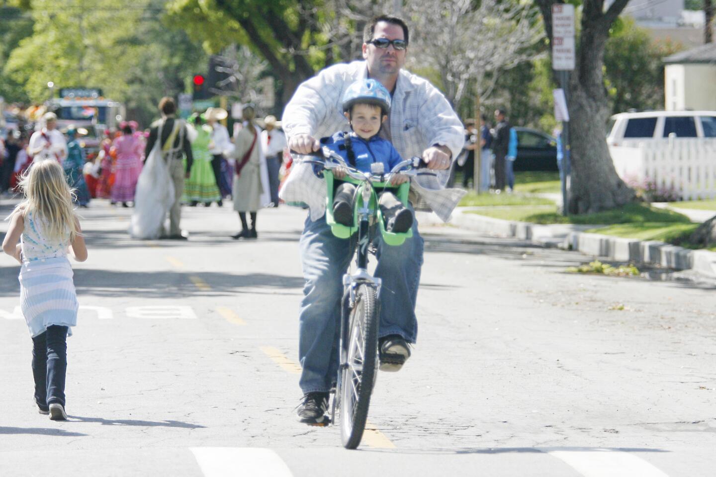 Blake Schroed, top, and his son, Carson, 4, stroll along Keystone St. before watching participants in Burbank on Parade, which took place on Olive Ave. between Keystone St. and Lomita St. on Saturday, April 14, 2012.