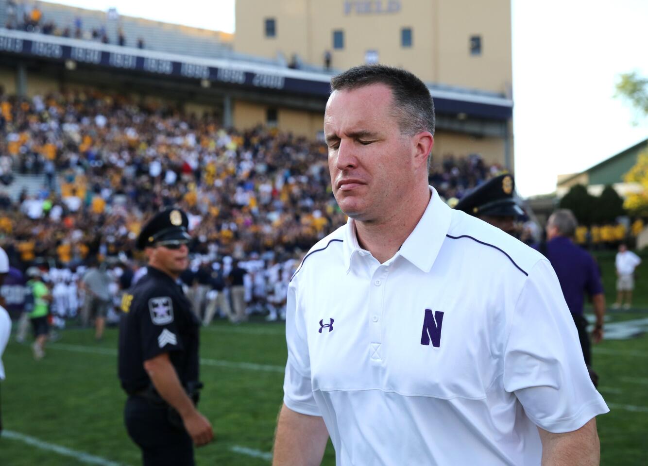 Pat Fitzgerald walks off the field after a 31-24 loss to California.