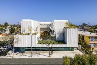 An aerial view of a white apartment structure centered around a raised outdoor courtyard 