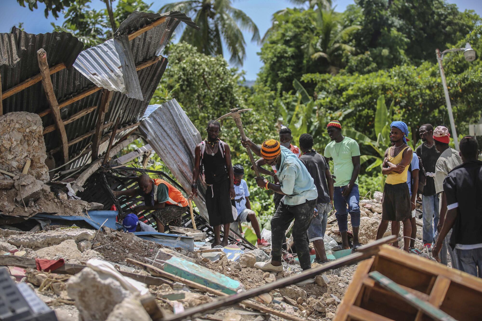 Locals search for victims in a home destroyed by an earthquake in Camp-Perrin, Les Cayes.