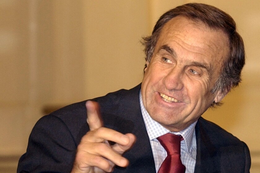 FILE - In this July 10, 2002 file photo, Carlos Reutemann, governor of Santa Fe, talks with aides during a ceremony at the Buenos Aires Government Palace. Reutemann, the Argentine ex-Formula One driver who entered politics after retirement, died at age 79 on Wednesday, July 7, 2021, according to his daughter Cora Reutemann. (AP Photo/Eduardo Di Baia, File)
