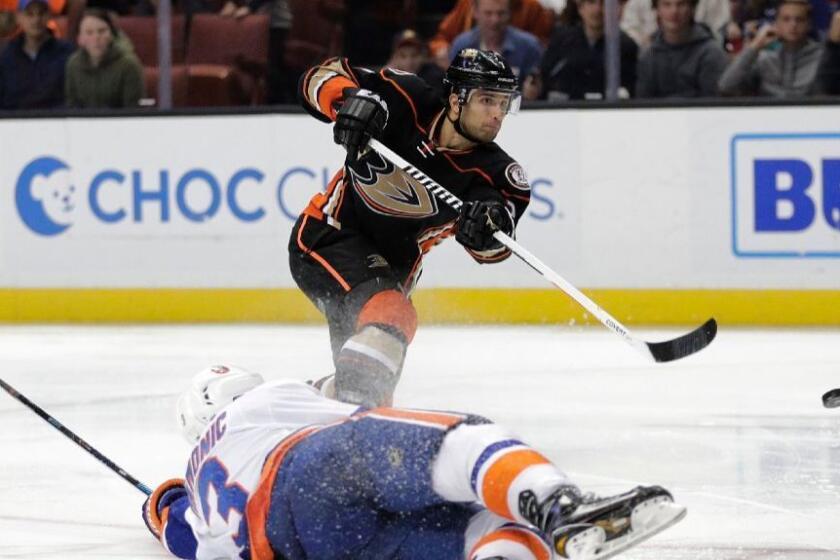 Ducks forward Andrew Cogliano puts a shot on net under pressure from Islanders defenseman Travis Hamonic during the second period of a game on Nov. 22.