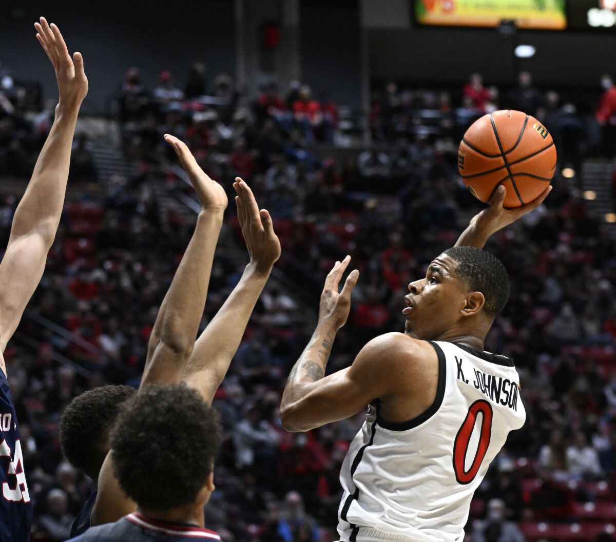 San Diego State Aztecs forward Keshad Johnson shoots over Fresno State Bulldogs defenders during the first half on Thursday.