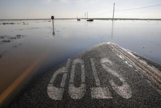 Vehicles are submerged in floodwaters on Ave. 56 near Central Valley Highway 43, a few miles north of Allensworth.