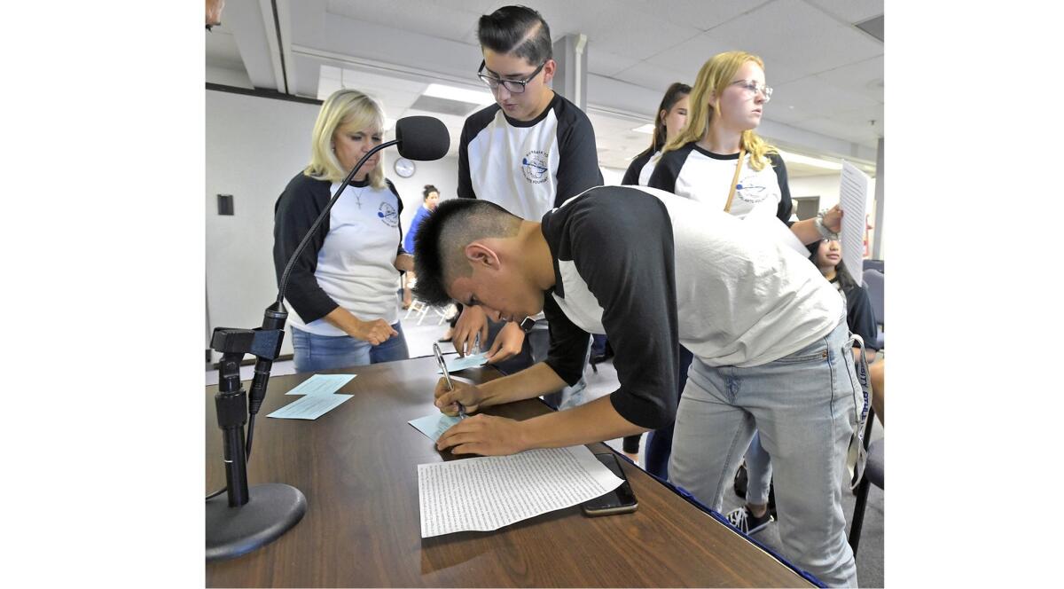In Sync dance captain Christopher Aguirre, 16, and Burbank High School choir members fill out speaking cards.