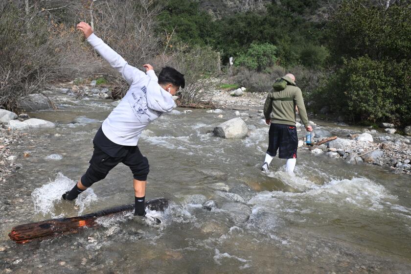 Pasadena, California January 12, 2023-A hiker slips in a creek in Eaton Canyon as recent storms have caused mudslides on local hiking trails. (Wally Skalij/Los Angeles Times)