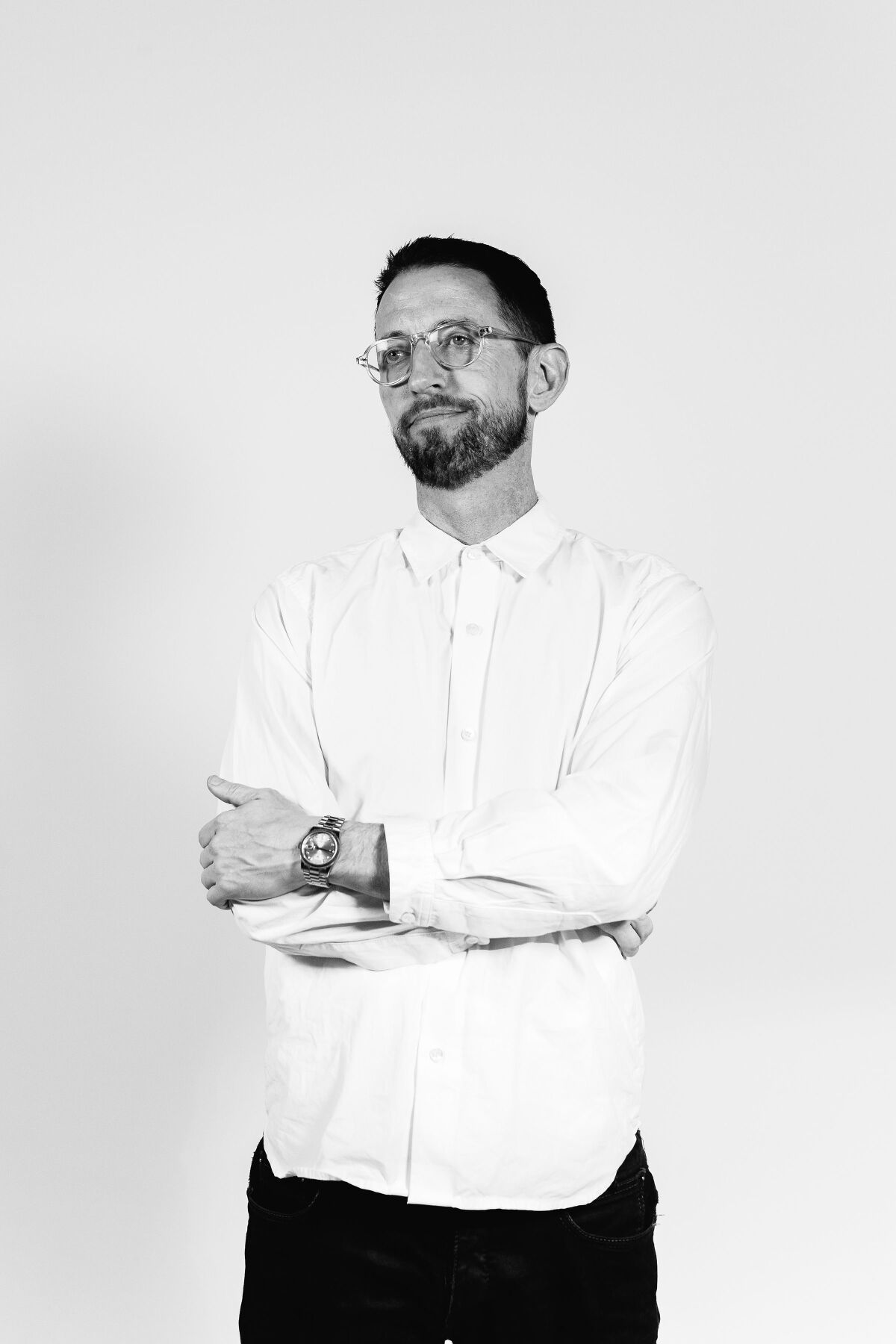 Bearded man in glasses and white collared shirt
