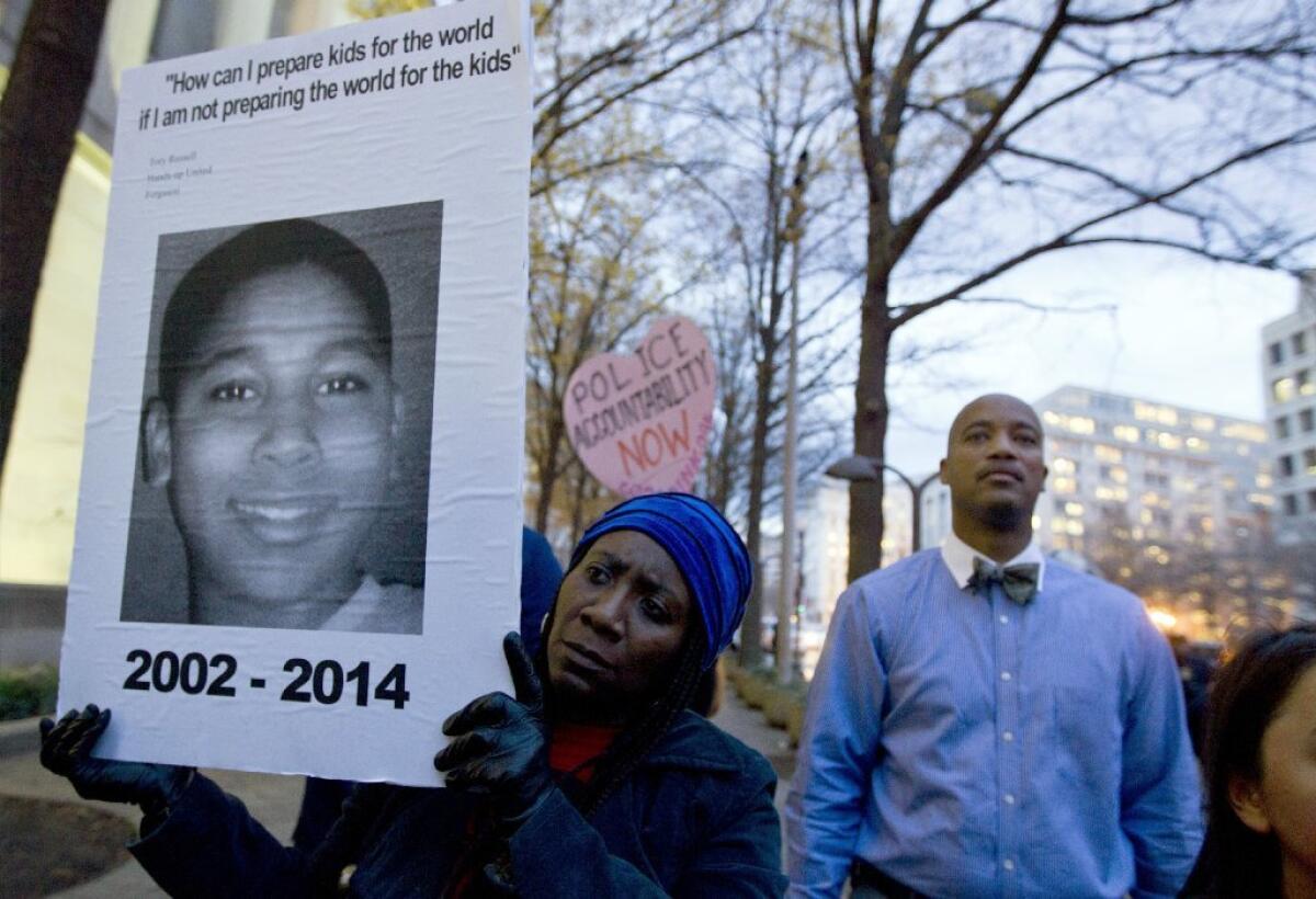 A demonstrator holds up a picture of Tamir Rice, a 12-year-old who was killed by police in 2014.