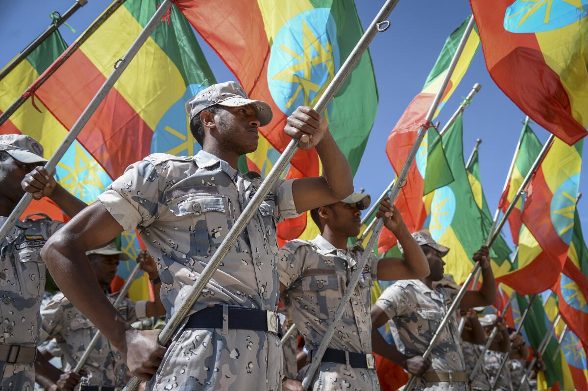 FILE - Members of the Ethiopian National Defense Force hold national flags as they parade during a ceremony to remember those soldiers who died on the first day of the Tigray conflict, outside the city administration office in Addis Ababa, Ethiopia, Nov. 3, 2022. A U.N. body devoted to promoting broader and better access to the internet is about to hold its latest annual gathering in Ethiopia, whose government has cut off internet access in the Tigray region during a two-year conflict. (AP Photo/File)