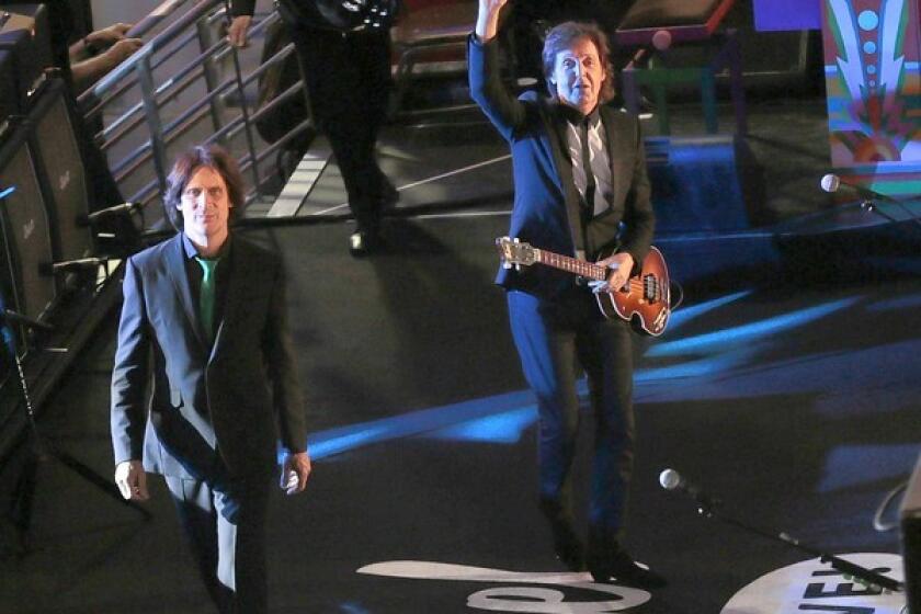 Paul McCartney, right, and guitarist Rusty Anderson arrive on stage to perform on Hollywood Boulevard.for "Jimmy Kimmel Live."