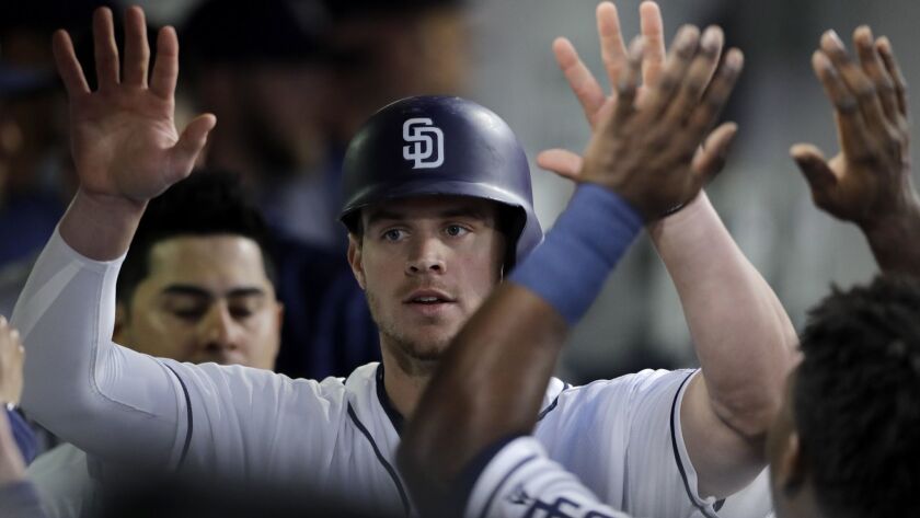San Diego Padres' Wil Myers is greeted by teammates in the dugout after hitting a home run during the third inning of a baseball game against the Pittsburgh Pirates Saturday, June 30, 2018, in San Diego.