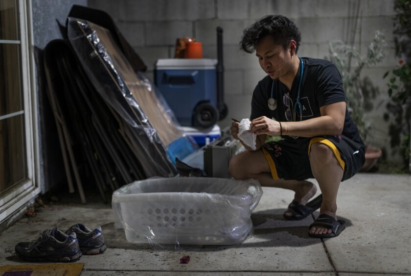 Nurse Justin Foronda disinfects his belongings in the backyard of his L.A. home as a precaution against the coronavirus. 