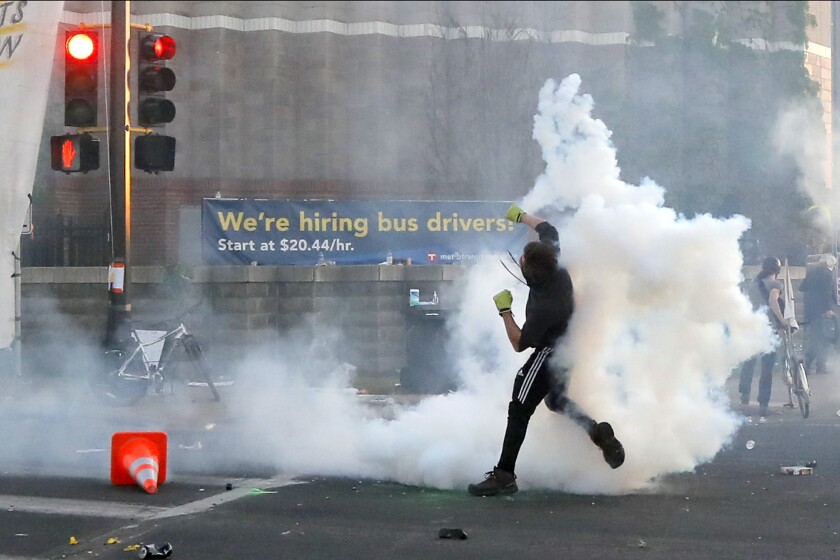 FILE - A protester launches a teargas canister back at Minnesota State Police, on May 30, 2020, in Minneapolis. George Floyd's death after his arrest by police officers in Minneapolis on May 25, 2020, sparked widespread anger after millions of people saw video of the event. The four officers at the scene were quickly fired and charged in his death. Officer Derek Chauvin was convicted of murder last year. The other three officers, Thomas Lane, J. Kueng and Tou Thao, now face a federal trial accusing them of violating Floyd's civil rights. Jury selection starts Thursday, Jan. 20, 2022. (AP Photo/Julio Cortez, File)