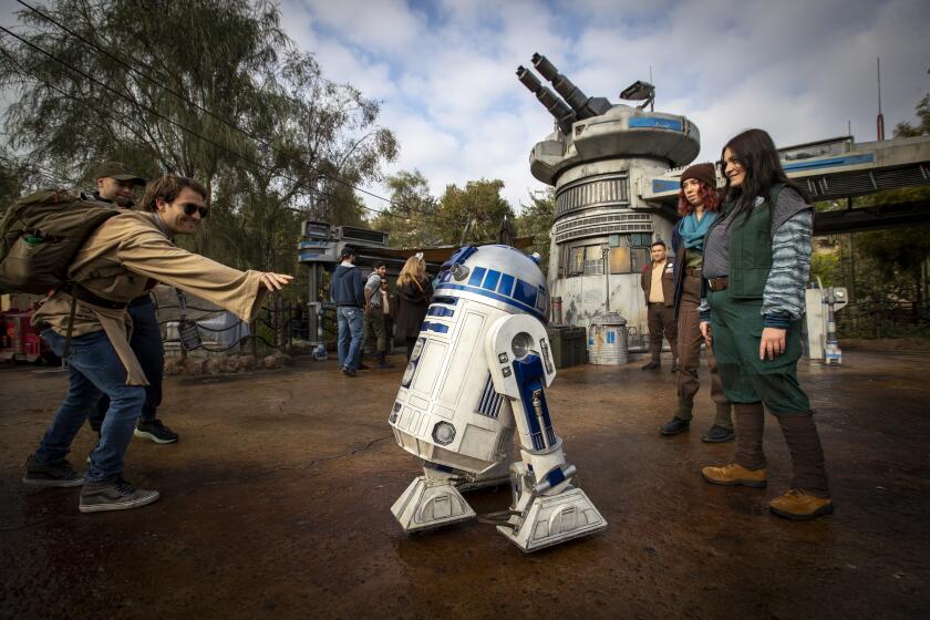 ANAHEIM, CALIF. -- THURSDAY, JANUARY 16, 2020: R2D2 and members of the Resistance interact with members of the media at the entrance featuring a large turret during a preview of Star Wars: Rise of the Resistance Media Preview at the Disneyland Resort in Anaheim, Calif., on Jan. 16, 2020. Star Wars: Galaxy's Edge (Allen J. Schaben / Los Angeles Times)