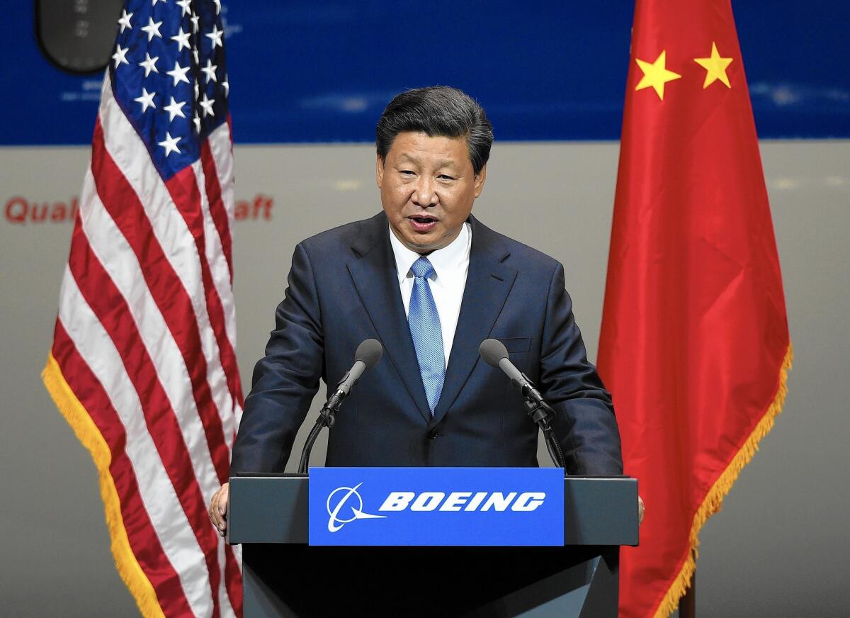 Chinese President Xi Jinping speaks after his tour of the Boeing assembly line in Everett, Wash. In deals signed during his U.S. visit this week, Chinese companies agreed to buy 300 Boeing jets and build the airliner's first assembly plant in China.