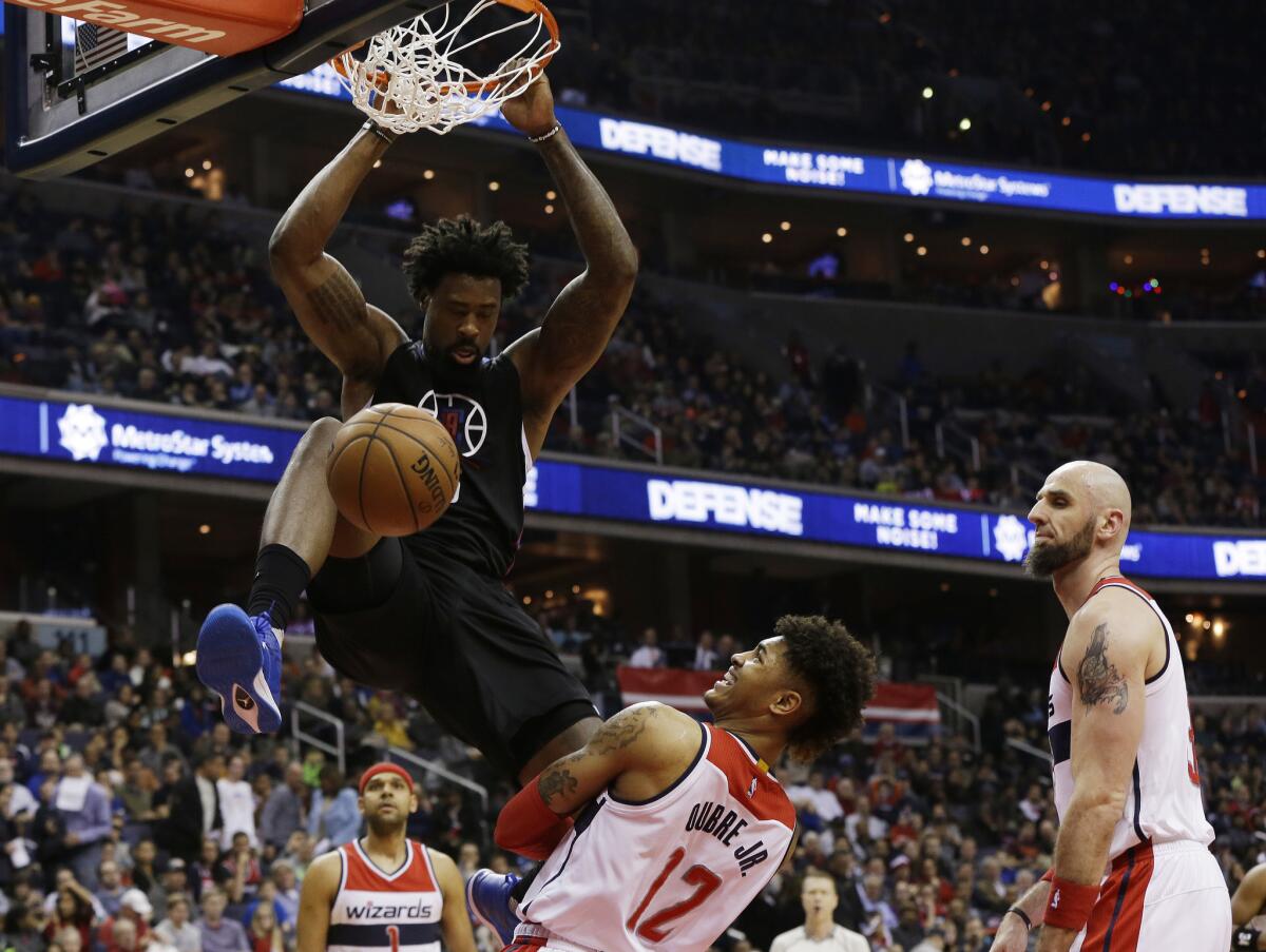 Clippers center DeAndre Jordan (6) dunks over Wizards forward Kelly Oubre Jr. (12), as the Wizards' Marcin Gortat (13) looks on during the first half.