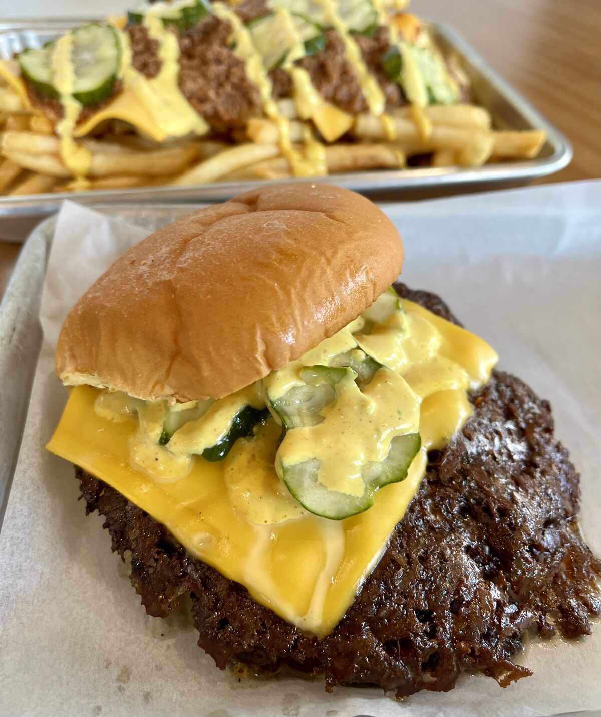 The Classic Hammer Burger is a smash burger with grilled onions, house-made pickles, cheese and Hammer sauce.