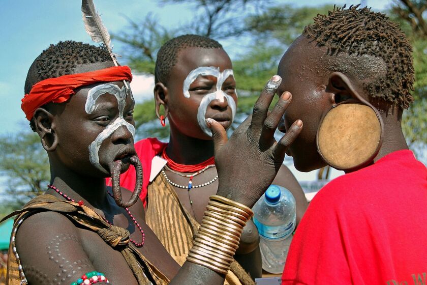 Here, three young Mursi women ready themselves for a tribal ceremony.