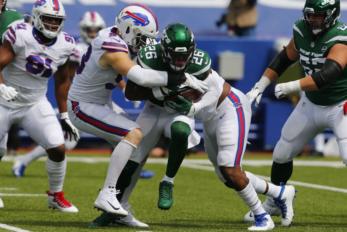 New York Jets running back Le'Veon Bell (26) is stopped by Buffalo Bills defensive ends Trent Murphy, center left, and Quinton Jefferson, center right, during the first half of an NFL football game in Orchard Park, N.Y., Sunday, Sept. 13, 2020. (AP Photo/Jeffrey T. Barnes)