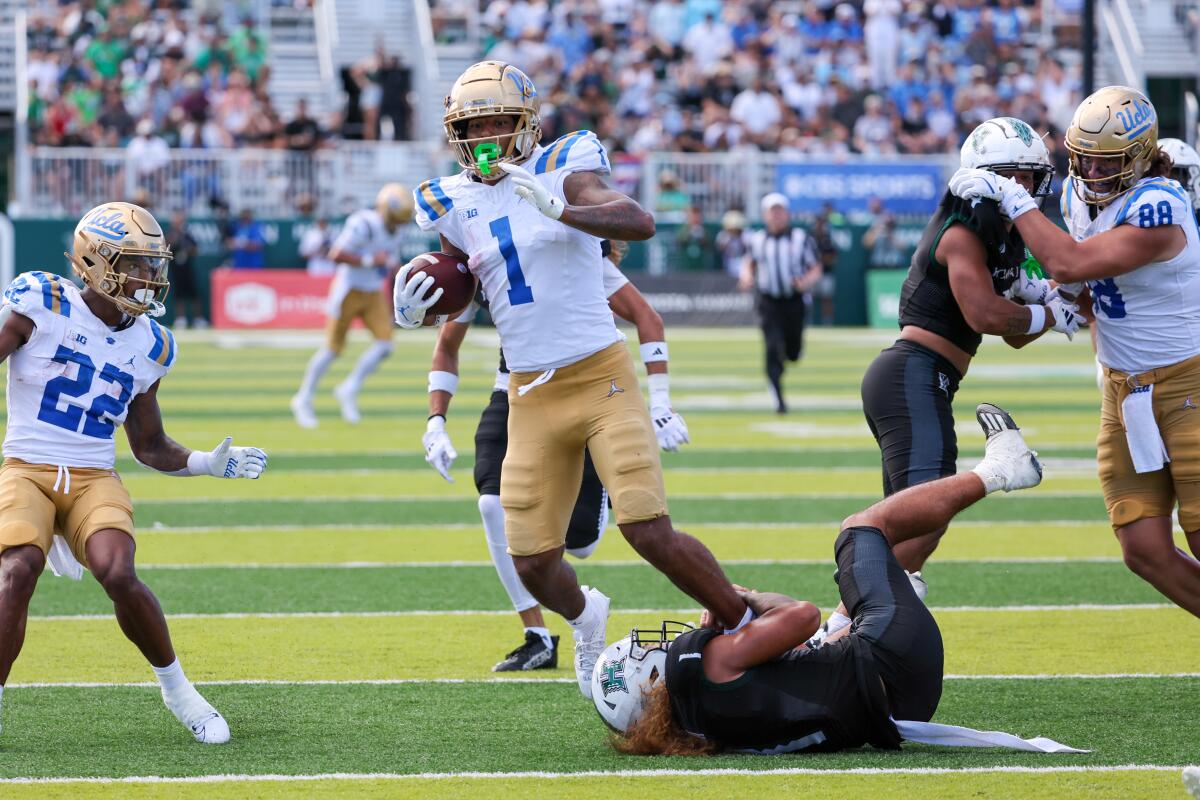 UCLA's  Rico Flores Jr. is tackled by Hawaii's Peter Manuma during the Bruins' win on Aug. 31 in Honolulu.