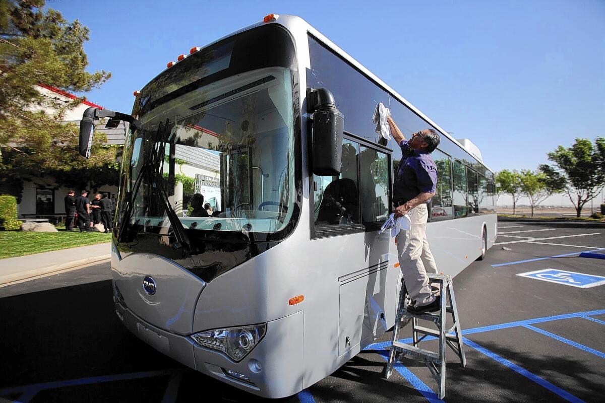 Chinese company Build Your Dreams failed to submit its goals for working with small businesses owned by minority or other disadvantaged groups before bidding. Above, a bus from the company is cared for by Joaquin Clara Lopez in Lancaster, where the firm has built a manufacturing plant.