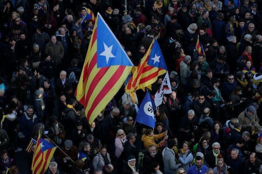 People, some with Catalonia independence flags, protest against Spain's cabinet holding a meeting in Barcelona Spain, Friday Dec. 21, 2018. Some scuffles have broken out between protesters trying to reach the venue of the cabinet meeting and police trying to stop them on Friday in central Barcelona after pro-independence organizations called for peaceful demonstrations against the meeting across the city. (AP Photo/Manu Fernandez)