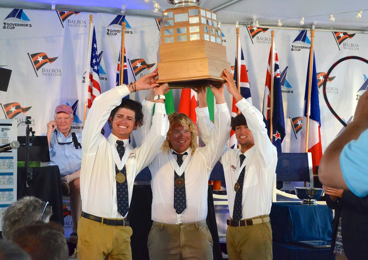 Jeffrey Petersen, with crew, Max Brennan and Enzo Menditto, raise the trophy as winners of the Governor's Cup.