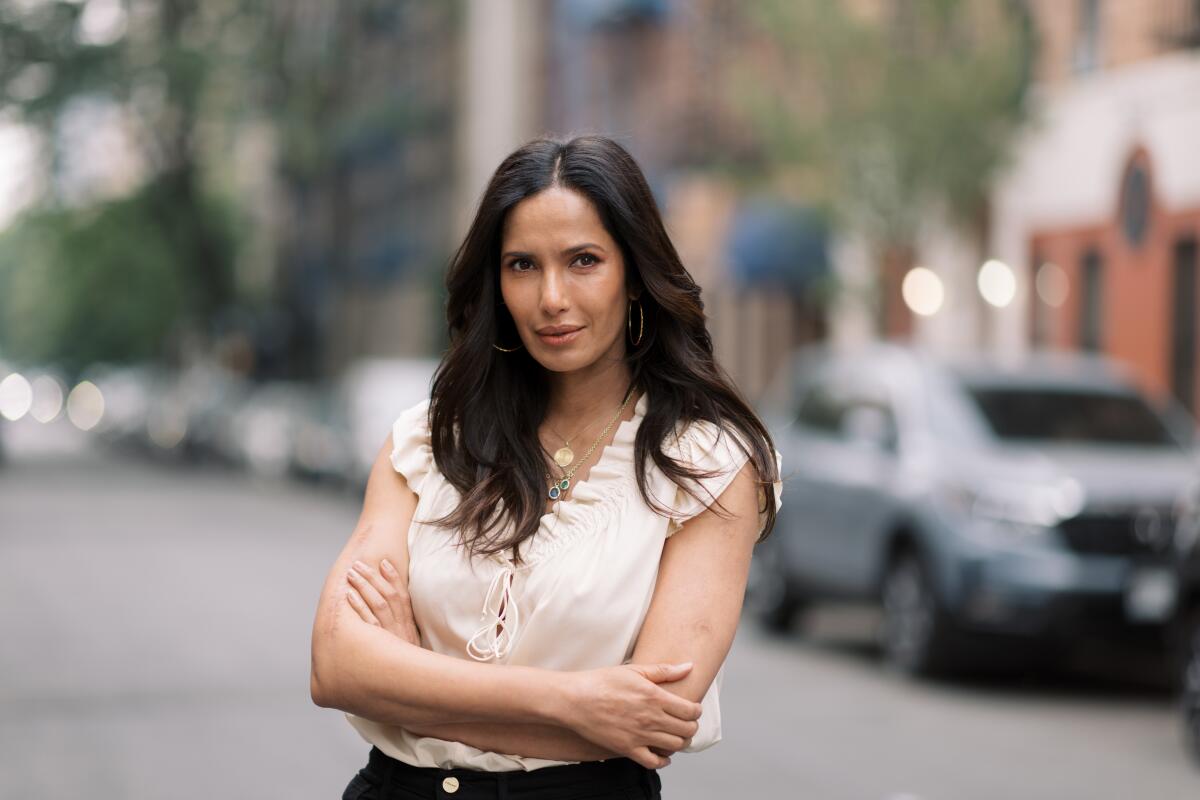 Padma Lakshmi, wearing a light blouse and gold necklace, in Manhattan's East Village.