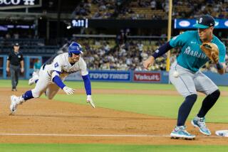 LOS ANGELS, CA - AUGUST 21, 2024: Los Angeles Dodgers outfielder Kevin Kiermaier (93) dives safely into third base as Seattle Mariners after hitting a triple as Seattle mariners third base Josh Rojas (4) receives the ball inside the baseline in the sixth inning at Dodgers Stadium on August 21, 2024 in Los Angeles, California. (Gina Ferazzi / Los Angeles Times)