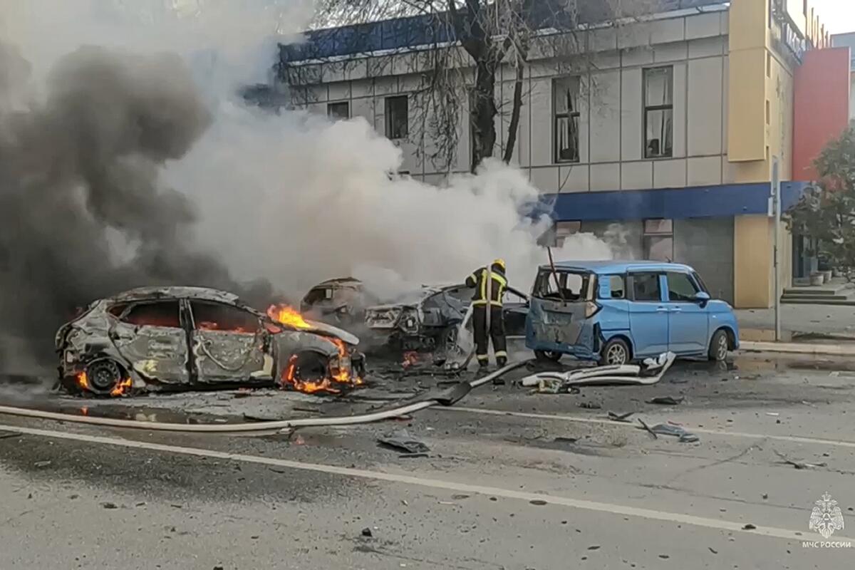 Firefighters extinguishing burning cars after shelling in Belgorod, Russia