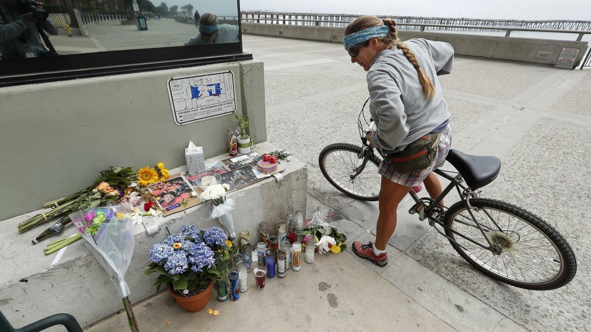 Alicia Carman, of Ventura, looks at the memorial for Anthony Mele Jr., 35, outside of Aloha Steakhouse, where Mele was stabbed to death by a homeless man as he was having dinner with his wife and daughter.